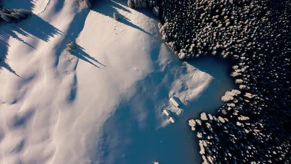 Top down view: Flying above Shelter in the Alps, Aerial of Winter Forest, Snow Covered 