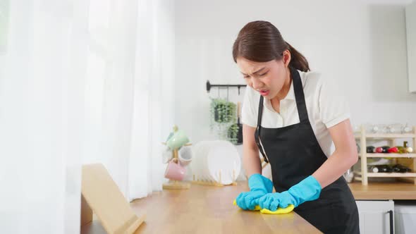 Asian young cleaning service woman worker clean kitchen table at home.