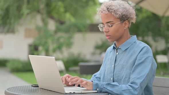 Thumbs Up By Young African Woman with Laptop in Outdoor Cafe