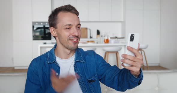 Young Man Talking to Smartphone Camera When Having Videocall Indoors