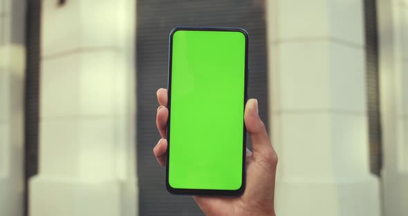 Close Up View of Female Hand Holding Smartphone with Mockup Blank Screen. Concept of Green Screen