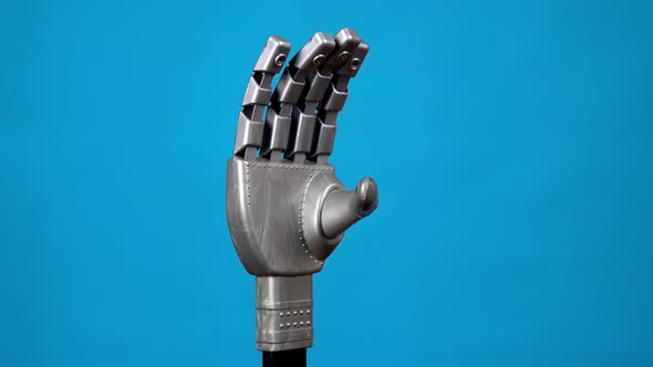 A Mechanical Hand Flexes Its Fingers and Shows a Rock Sign. Gray Cyborg Arm Came To Life and Began