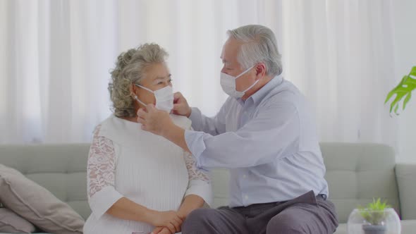 Happy Asian Elderly or Seniors couple wearing medical mask together to prevent coronavirus