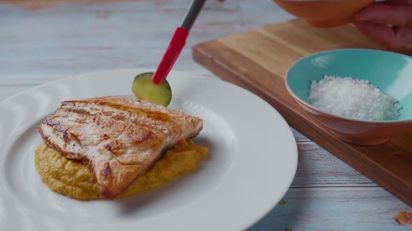 Serving healthy mashed sweet potato with coconut milk and grilled salmon. Clip represents healthy pa