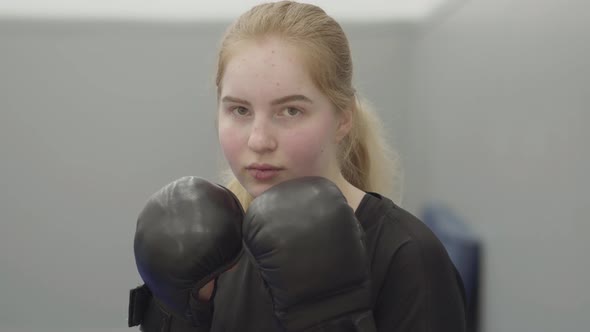 Portrait of Confident Blond Woman in Boxing Gloves Imitating Dodging Blows in the Gym Close Up. Cute