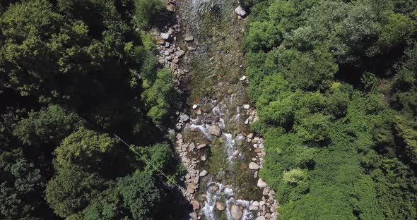 Aerial View of River Flowing Trough Rocks of Mountain in a Summer Sunny Day