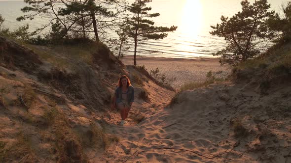 Happy Young Woman Runs Uphill Towards Dronw After Enjoying Amazing Sunset at Baltic Sea