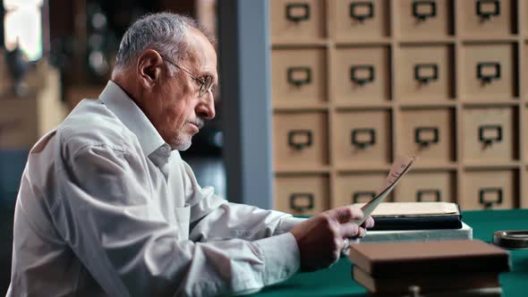 Pensive 70s Elderly Business Man Reading Paper Letter From Tax Office Working Sitting at Desk Table