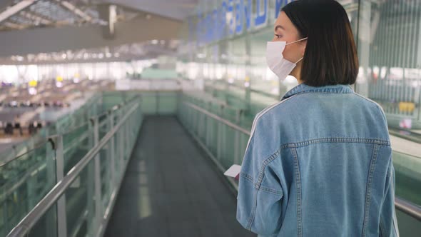 Woman passenger wearing face mask walking in airport terminal to boarding gate during the COVID19.