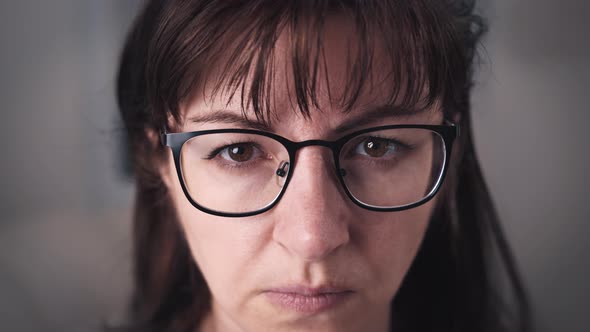 Woman Examines with a Glance Serious Brunette Woman Attentively Looks at the Camera Closeup Observes