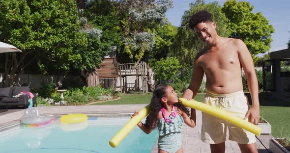 Happy biracial father and daughter spending time at pool together