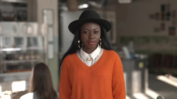 Smiling Young Woman with Black Skin Standing at Cafe