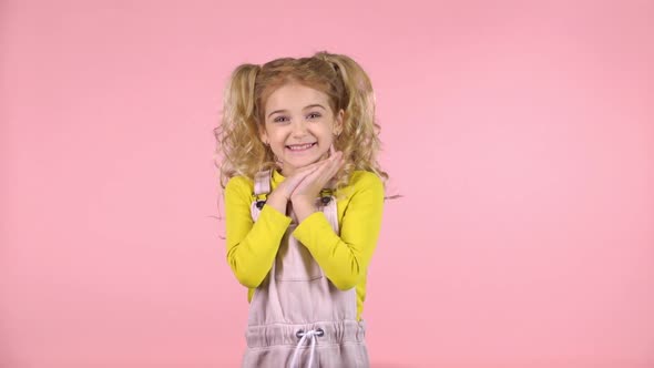 Little Girl Is Surprised at Studio on Pink Background. Slow Motion