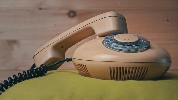 Old Home Wired Telephone is Spinning on a Wooden Background