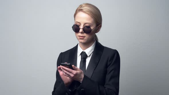 businesswoman in a classic business suit typing on mobile phone