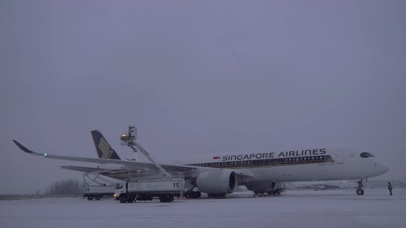 Anti-icing spraying before airplane departure in winter evening