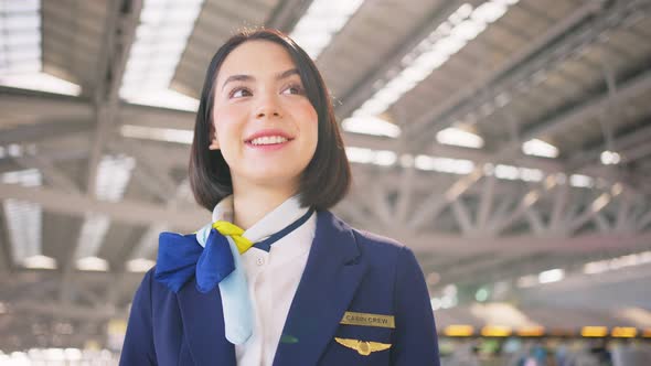 Beautiful Caucasian flight attendant staff smile and walk with confidence face in airport terminal.