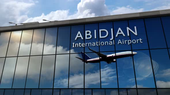 Airplane landing at Abidjan Ivory Coast airport mirrored in terminal