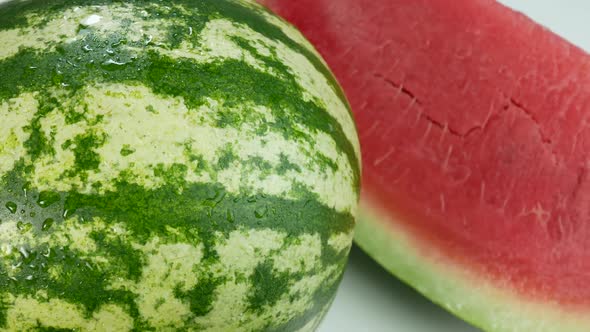 Watermelon Covered In Drops Of Water And A Delicious Slice On White Surface