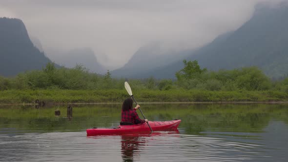 Adventure Caucasian Adult Woman Kayaking in Red Kayak