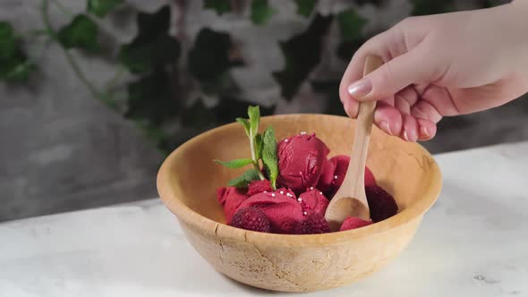 Female Hand Takes with a Spoon Raspberry Sorbet From the Bowl