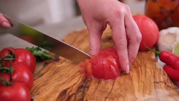 Woman Cutting Peeled Tomato Using Kitchen Knife