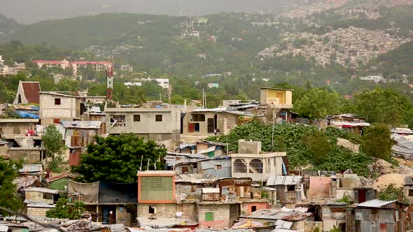 Long shot of a slum in Port-au-Prince with other parts of the city crawling up the side of a mountai