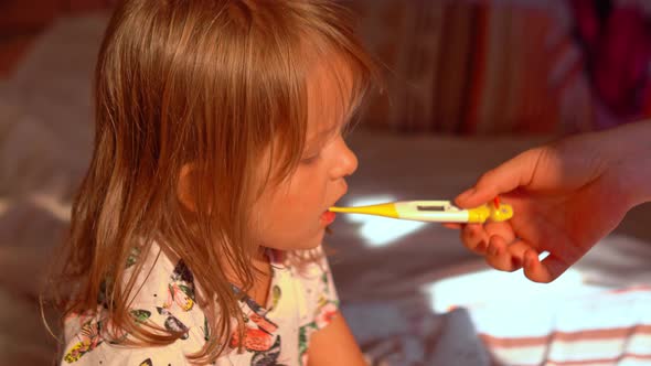 Mother is Measure the Temperature of Little Kid Girl