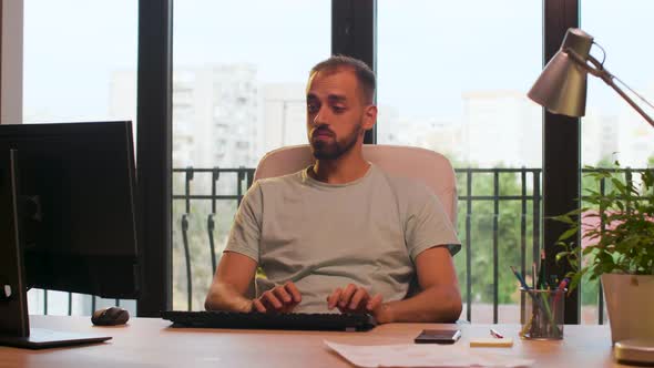 CEO of Start Up Company Typing on Computer and Looking at the Phone in Warm Sunset Light