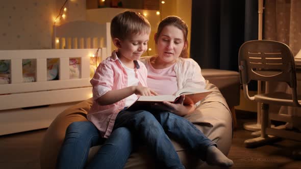 Slow Motion of Young Mother Reading Bedtime Story To Her Little Son Before Going To Sleep