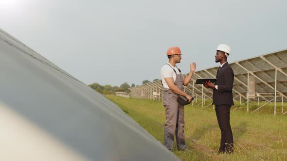 African American Man in Black Suit and White Helmet Walking with Indian