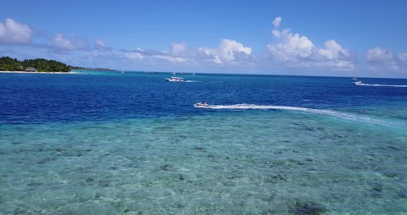 Daytime drone abstract shot of a white sand paradise beach and blue sea background in colourful 4K