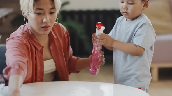Asian Woman with Son Wiping Table at Home