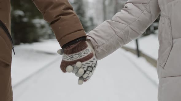 Unrecognizable People Holding Hands and Walking in Winter