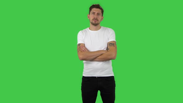 Confident Guy Is Looking Straight and Crossing His Arms Over His Chest. Green Screen