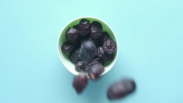 Slow Motion of Dropping Fresh Date Fruit in a Bowl on Table