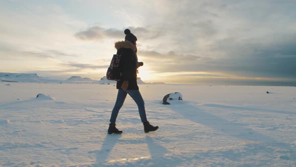 Yong Beautiful Woman Traveler Walking on Snow Desert in Iceland