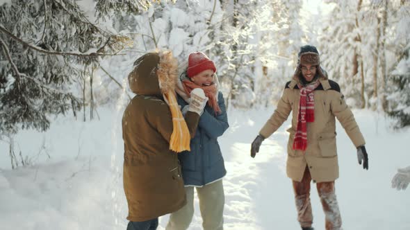 Laughing Friends Playing in Forest on Winter Day