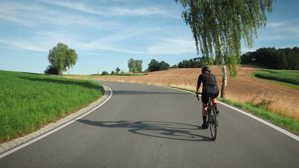 Woman riding bicycle at sunset