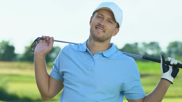 Handsome Golfer in Professional Uniform Smiling to Camera Posing With Club
