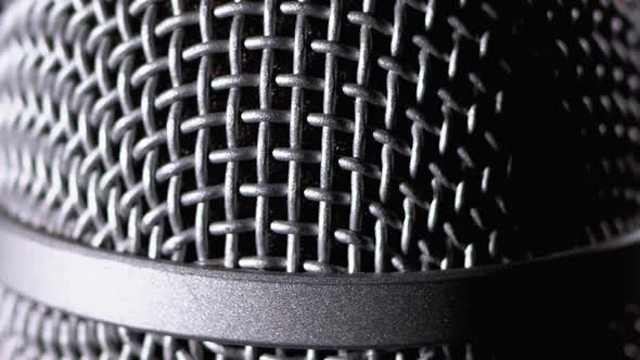 The Microphone Rotates on a Black Background. Dynamic Microphone Grid Spins Close-up