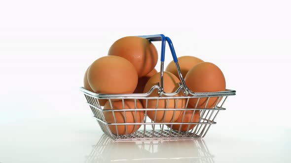 Chicken Eggs In Brown Color In A Supermarket Basket With Copy Space, Rotate On A White Table Chicken