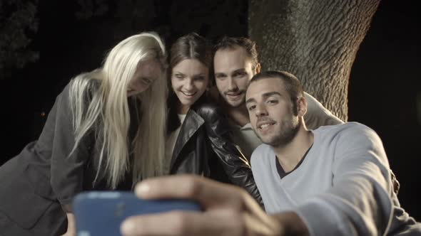 Group of Four Happy Men and Women Friends Shoot a Selfie in Outdoor Rural Scenic at Night