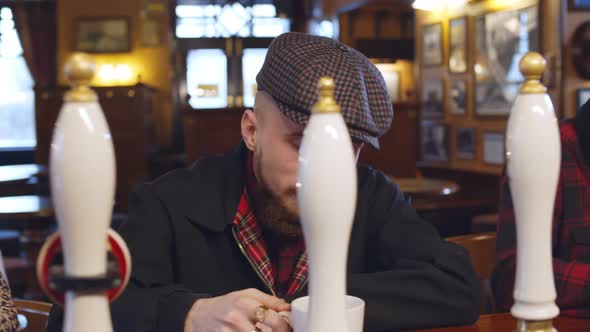 Diverse People Sitting at Bar Counter Using Smartphone and Drinking in Pub