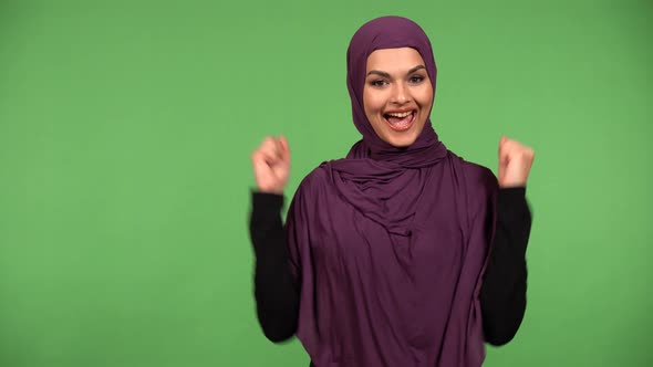 A Young Beautiful Muslim Woman Celebrates with a Smile  Green Screen Background