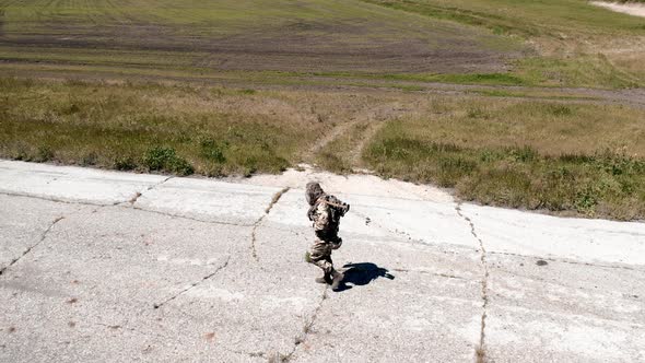 Aerial View of a Lonely Soldier Walks Along an Old Concrete Road