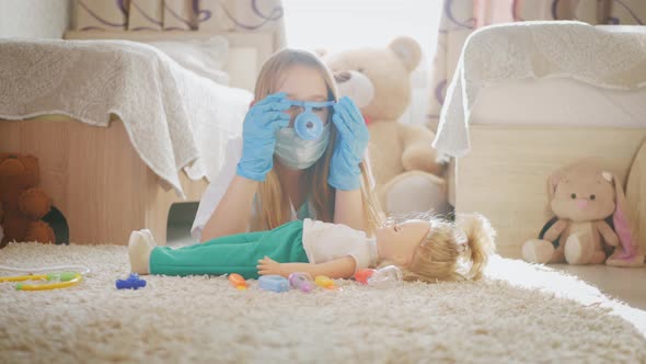 Beautiful Little Girl Playing Doctors with Doll at Home