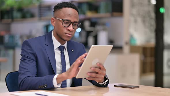 Serious Professional African Businessman Using Tablet in Office 