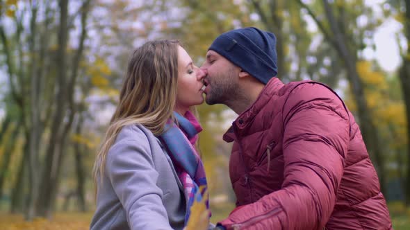 Affectionate Couple in Tender Kiss in Autumn Park