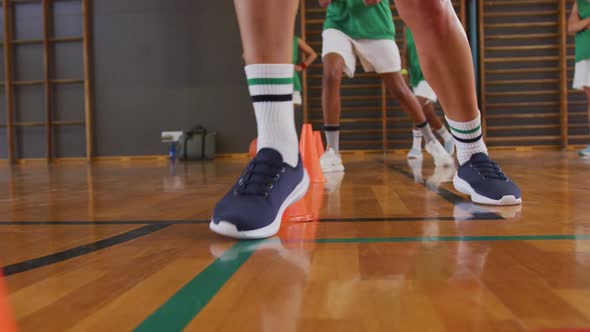 Mid section of diverse female basketball team practice dribbling ball